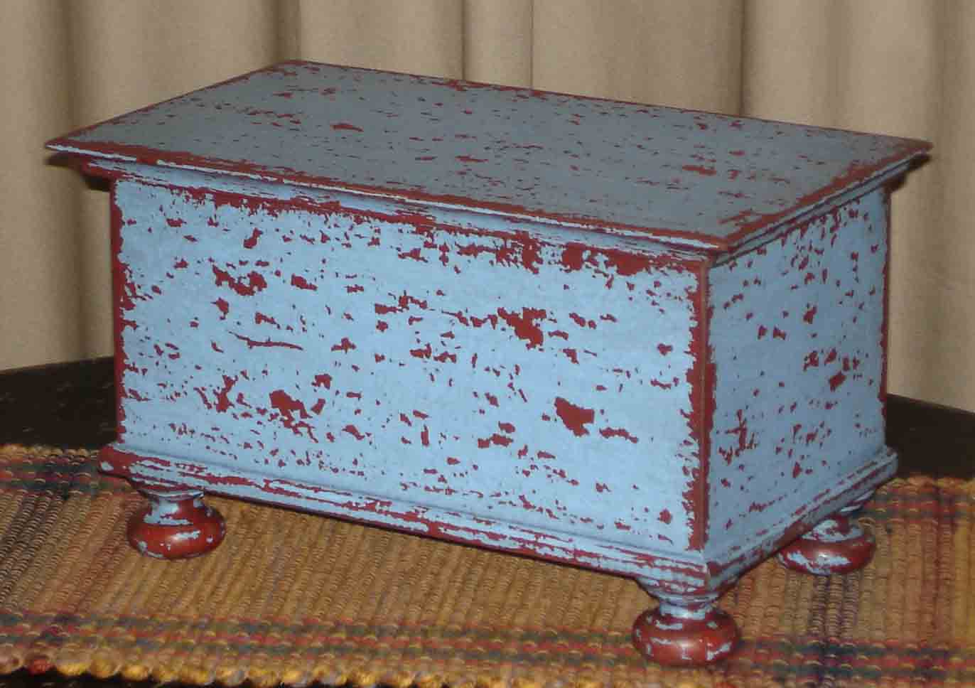 Blue over Red Wood Bunfoot Keepsake box. Handmade in Ohio. Box is hand painted & distressed. Our finish uses layers of color and aging that creates our unique look. Great for small treasures and keepsakes. Use in any room, on a table, mantle or shelf. Compliments design styles including primitive, farmhouse, rustic & traditional. 